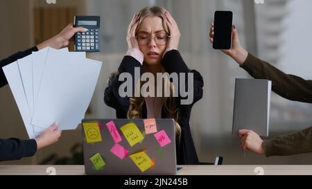Front view overworked exhausted tired business girl woman worker manager in glasses holding head multitasking stress problem with work sitting table Stock Photo