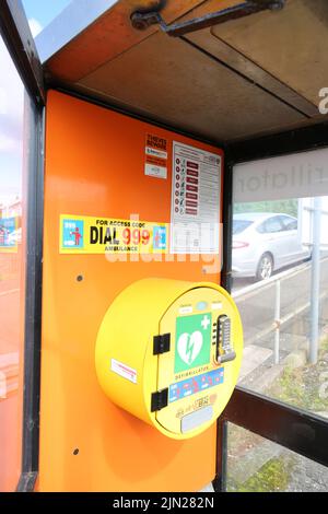 Dunure, Ayrshire, Scotland, UK. Former telephone box kiosk now converted to hold a defibrillator in the small coastal village. Located in a small car park Stock Photo