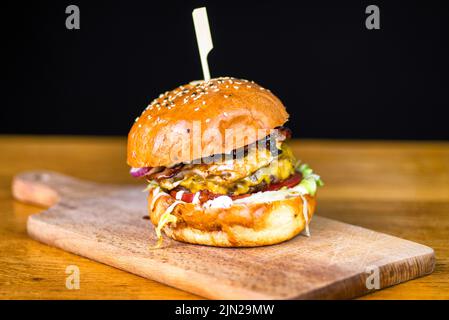 fresh tasty burger on table and black background. unhealthy fast food Stock Photo