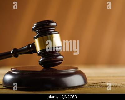 Close-up. On a beige background, a wooden gavel of a judge and an open book. Fair court, auction, courtroom, constitution, bible, rule of law. Minimal Stock Photo