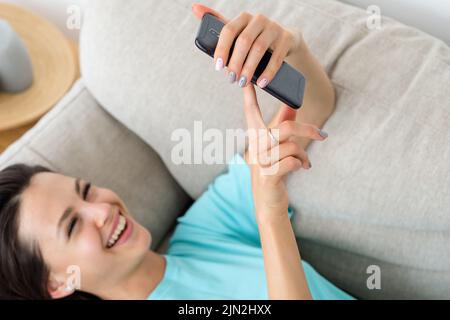 laugh woman couch phone idle lifestyle addiction Stock Photo
