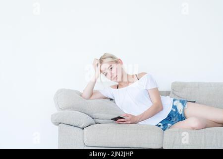 woman laying couch phone idle lifestyle addiction Stock Photo