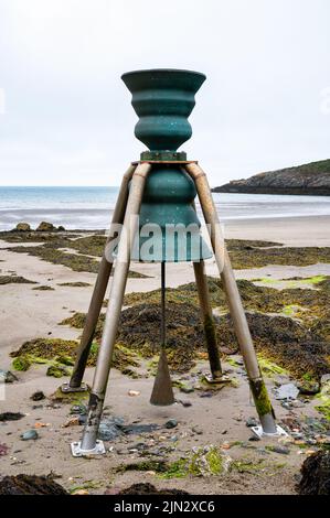 The tide bell at  low tide on the beach at Cemaes on the island of Anglesey in North Wales Stock Photo