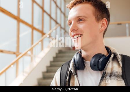 Close up portrait of a smiling male student in college looking at window Stock Photo