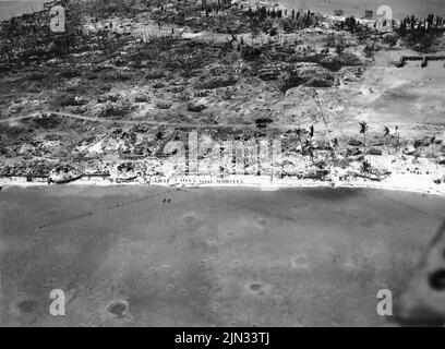 Aerial view of Betio, Tarawa Atoll, 24 November 1943, looking north toward 'The Pocket', the last place of Japanese resistance. An emplacement just onshore with two 12.7 mm anti-aircraft guns is visible near the left edge of the photograph. Stock Photo