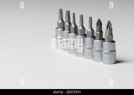 Screwdriver bits, different designs on grey background. Copy space. Close up Stock Photo