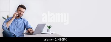 Cheerful Middle Aged Man Working Remotely From Home Office Stock Photo