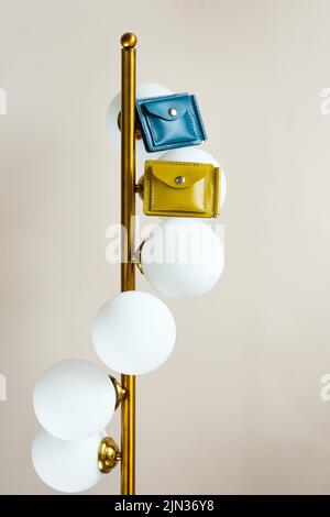 Two colored leather wallets placed on a lamp indoors Stock Photo