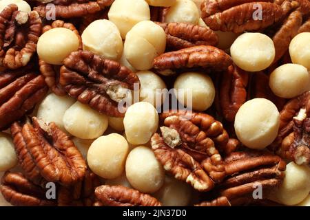 Big shelled pecan nuts and macadamia nuts situated arbitrarelly. Top down view Stock Photo