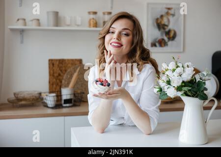 Girl holding a cake in her hands while standing in the kitchen Stock Photo