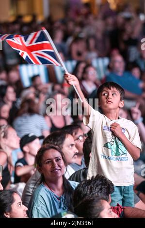 Victoria Square, Birmingham, England, August 8th 2022. - A boy waves a union flag as thousands of spectators crammed in to Victoria Square in Birmingham to watch the closing ceremony of the 2022 Commonwealth Games. Pic by Credit: Sam Holiday/Alamy Live Newsr Stock Photo