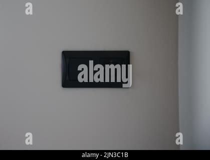 Black modern light switch and light dimmer on gray wall with copy space Stock Photo