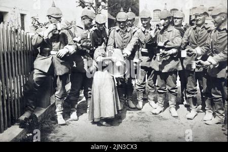 Early First World War era group of German soldiers taking refreshments from a small woman with a large jug c.1914 Stock Photo