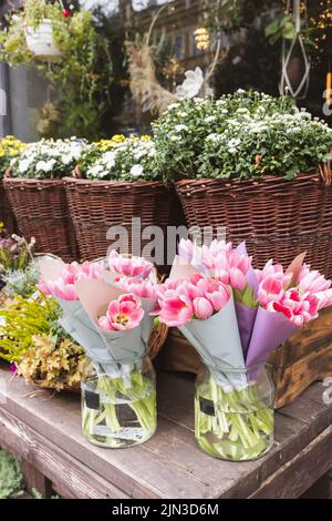 Tulips, heather, chrysanthemum and hanging flowers and wreaths at the flower shop. Halloween and Thanksgiving autumn decoration with flowers in trendy rattan baskets Stock Photo