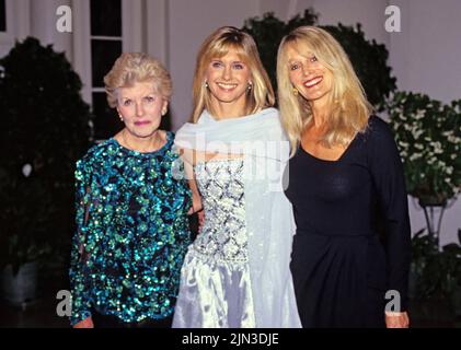 Australian singer, songwriter and actress Olivia Newton-John, center, arrives for the State Dinner hosted by United States President George H.W. Bush and first lady Barbara Bush honoring President Václav Havel of Czechoslovakia at the White House in Washington, DC with her mother, Irene Newton-John, left, and sister, Rona Newton-John, right, on October 22, 1991. Credit: Ron Sachs/CNP Stock Photo