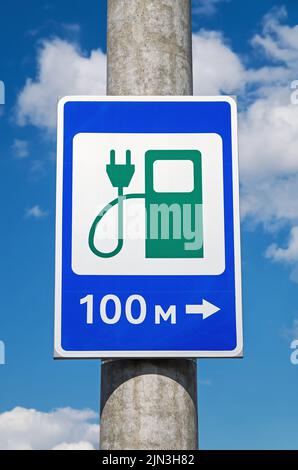 Road sign - electric charging station hanging on large reinforced concrete pole Stock Photo