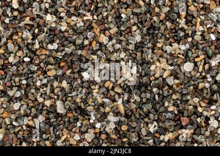 Sea sand (Gran Canaria beach, Spain) with dark volcanic particles few ocean shell remains visible. Microscope photo, image width 9mm Stock Photo