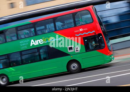 A panning shot of a moving double decker bus in Leeds City Centre  operated by The Keighley Bus Company. Stock Photo