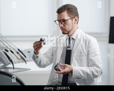 Dentist looking at photopolymer jaw printed on a 3d printer. Stock Photo