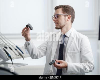Dentist looking at photopolymer jaw printed on a 3d printer. Stock Photo