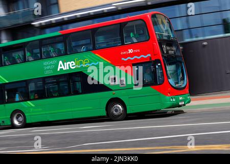 A panning shot of a moving double decker bus in Leeds City Centre  operated by The Keighley Bus Company. Stock Photo