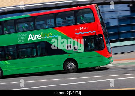 A panning shot of a moving double decker bus in Leeds City Centre  operated by The Keighley Bus Company. Stock Photo