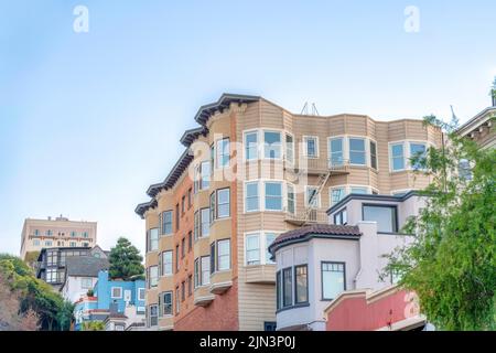 Low-rise residential buildings on a sloped suburbs of San Francisco, CA. Row of buildings with single-family houses and apartment buildings with emerg Stock Photo