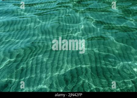 Crystal clear water rippled and sunny reflections on the surface of the sea. Natural background Stock Photo