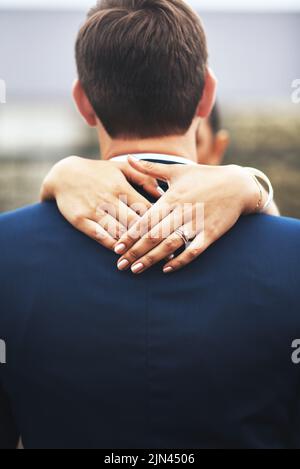 Ill never turn my back on her and our marriage. Rearview shot of an unrecognizable newlywed young couple hugging and embracing on their wedding day. Stock Photo