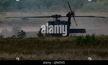 Operators from the 20th Special Forces Group exit a UH-60 Blackhawk helicopter to assault an objective during a live fire training exercise near Chester Township, Michigan, August 6, 2022. The mission was part of Northern Strike, an annual multinational joint training event headquartered at the Camp Grayling Joint Maneuver Training Center in Michigan. (U.S. Army National Guard photo by Spc. Cody Muzio.) Stock Photo