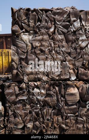Bales of crushed and compacted gas tanks at scrap metal recycling yard. Stock Photo