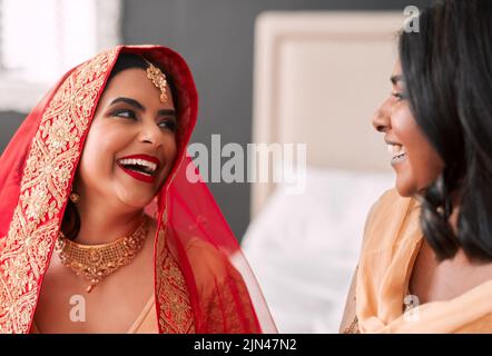 Some of the best memories are made before the wedding. a young woman getting getting ready for her wedding with her bridesmaid. Stock Photo