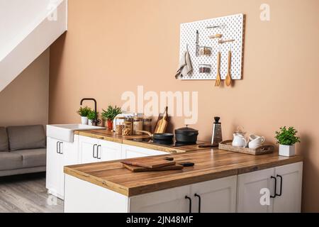 Interior of stylish kitchen with white counters, utensils and pegboard Stock Photo