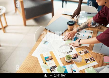 Lets move these two ideas around. two unrecognizable businesswomen standing and working with technology and documents during a strategy meeting. Stock Photo