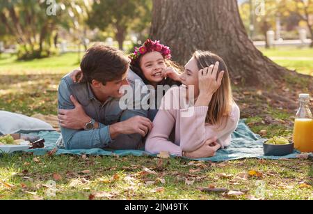 Nothing says family time like a picnic in the park. a happy young family enjoying a picnic in the park. Stock Photo