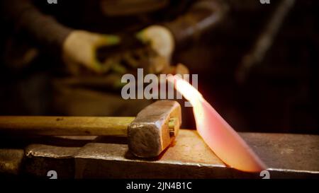 A man blacksmith making a knife out of metal Stock Photo
