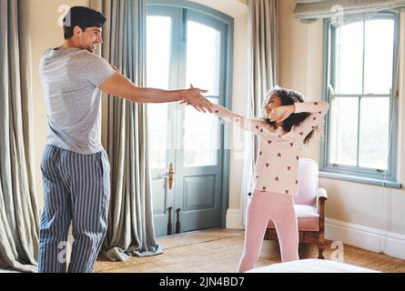 Practising her dance moves with Dad. a father and his little daughter dancing together at home. Stock Photo