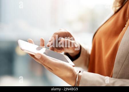 These apps make handling my business so much easier. an unrecognizable businesswoman using a mobile phone in her office. Stock Photo
