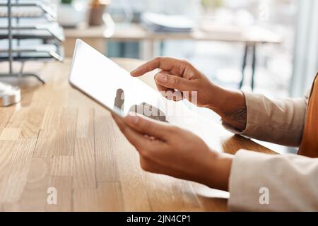 One touch is all it ever takes. an unrecognizable businesswoman using a digital tablet in her office. Stock Photo
