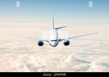 Passenger airplane flies above the clouds and forest fields landscape ...