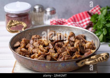 Muslims Traditional Sacrifice holiday food lamb, Turkish roasted meat in copper pot on table top. Turkish Kavurma. (Turkish name; Kurban kavurma) Stock Photo