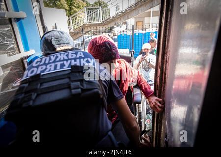 August 6, 2022, Donetsk Oblast, Donets'ka Oblast'', Ukraine: A police officer is seen helping an old lady in a wheelchair to board the evacuation train. Amid the intensified fighting in the Eastern part of Ukraine, east Ukraine is now intensifying its civilian evacuation, as millions of Ukrainian families have been evacuating from the closer and closer war, as many of them will be relocated to the western part of the country.According to the United Nations, at least 12 million people have fled their homes since Russia's invasion of Ukraine, while seven million people are displaced inside th Stock Photo