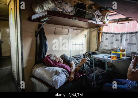 August 6, 2022, Donetsk Oblast, Donets'ka Oblast'', Ukraine: An old lady is seen resting in the evacuation train going to Dnipro. Amid the intensified fighting in the Eastern part of Ukraine, east Ukraine is now intensifying its civilian evacuation, as millions of Ukrainian families have been evacuating from the closer and closer war, as many of them will be relocated to the western part of the country.According to the United Nations, at least 12 million people have fled their homes since Russia's invasion of Ukraine, while seven million people are displaced inside the country. (Credit Imag Stock Photo