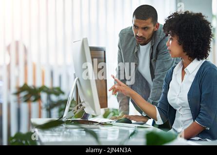 Professional businesswoman, designer or manager talking with worker at a workstation in an office. Teamwork during business meeting, working and Stock Photo