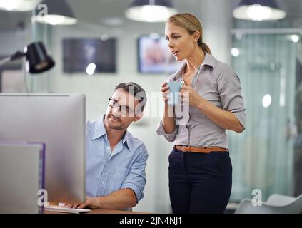 Professional businesspeople developing strategy, share ideas and brainstorm in front of computers in the office space. Business colleagues analyzing Stock Photo