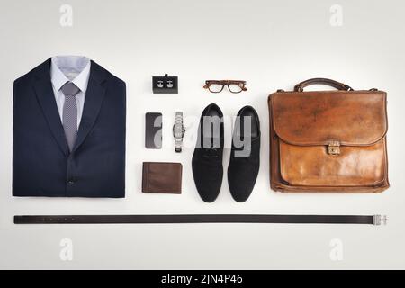Flatlay of business suit, corporate formal attire with fashion accessories  on a white table background. Still life above view of modern clothing style  with phone for a professional and neat lifestyle Stock