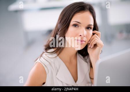 Serious, confident and motivated manager, leader or boss sitting in her office, working and looking ambitious. Portrait of a young professional Stock Photo