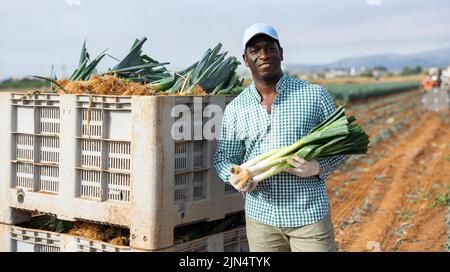 Portrait of positive farmer with leek crop Stock Photo