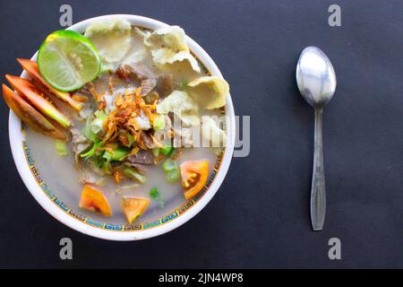 sop kaki kambing a traditional food from Betawi, Jakarta Indonesia, made from mutton or lamb, offal, spices. isolated on black background.This food is Stock Photo