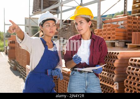 Female workers having conversation in outdoot warehouse Stock Photo